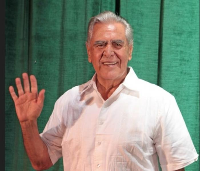 actor poartă o cămașă albă cu mâneci scurte