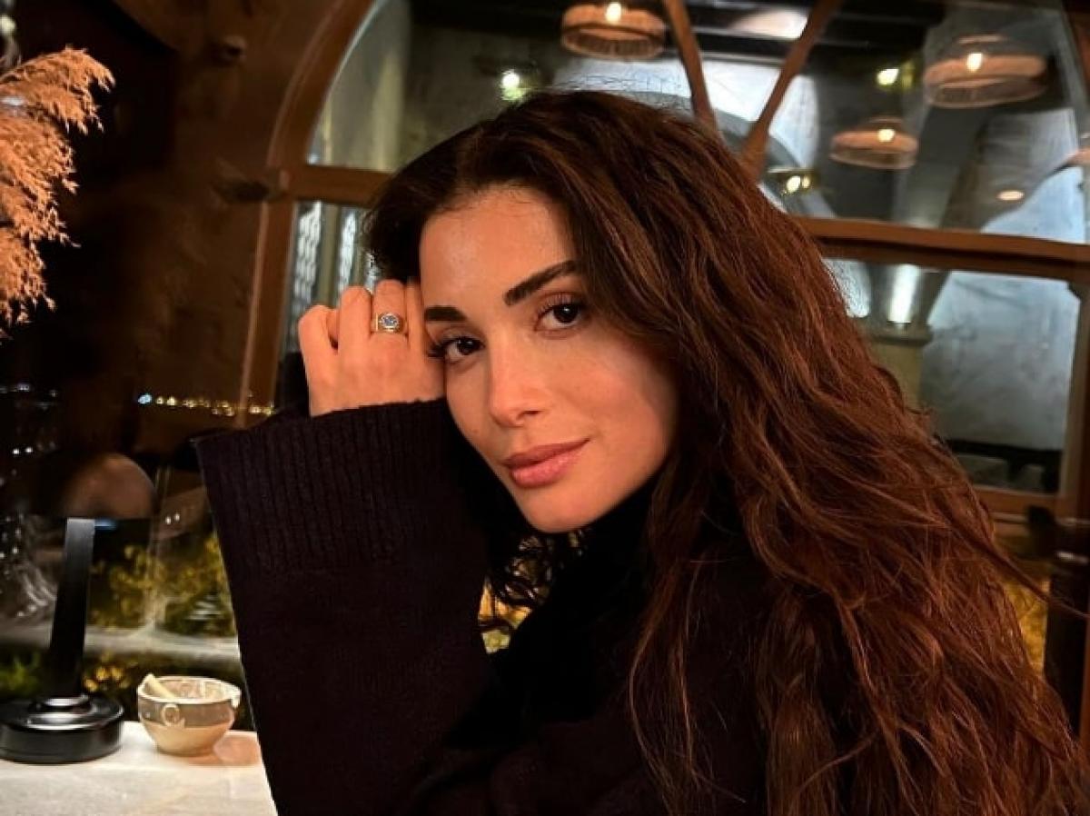 actrița poartă o bluză neagră cu mâneci lungi