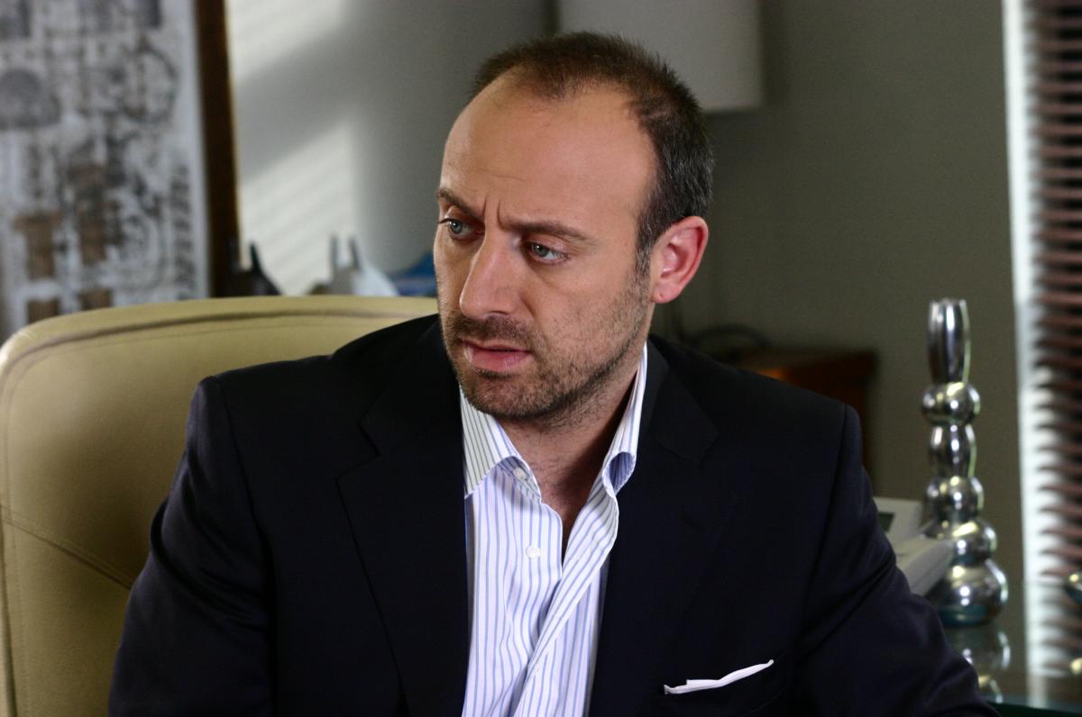 actor poartă o cămașă albă și sacou negru