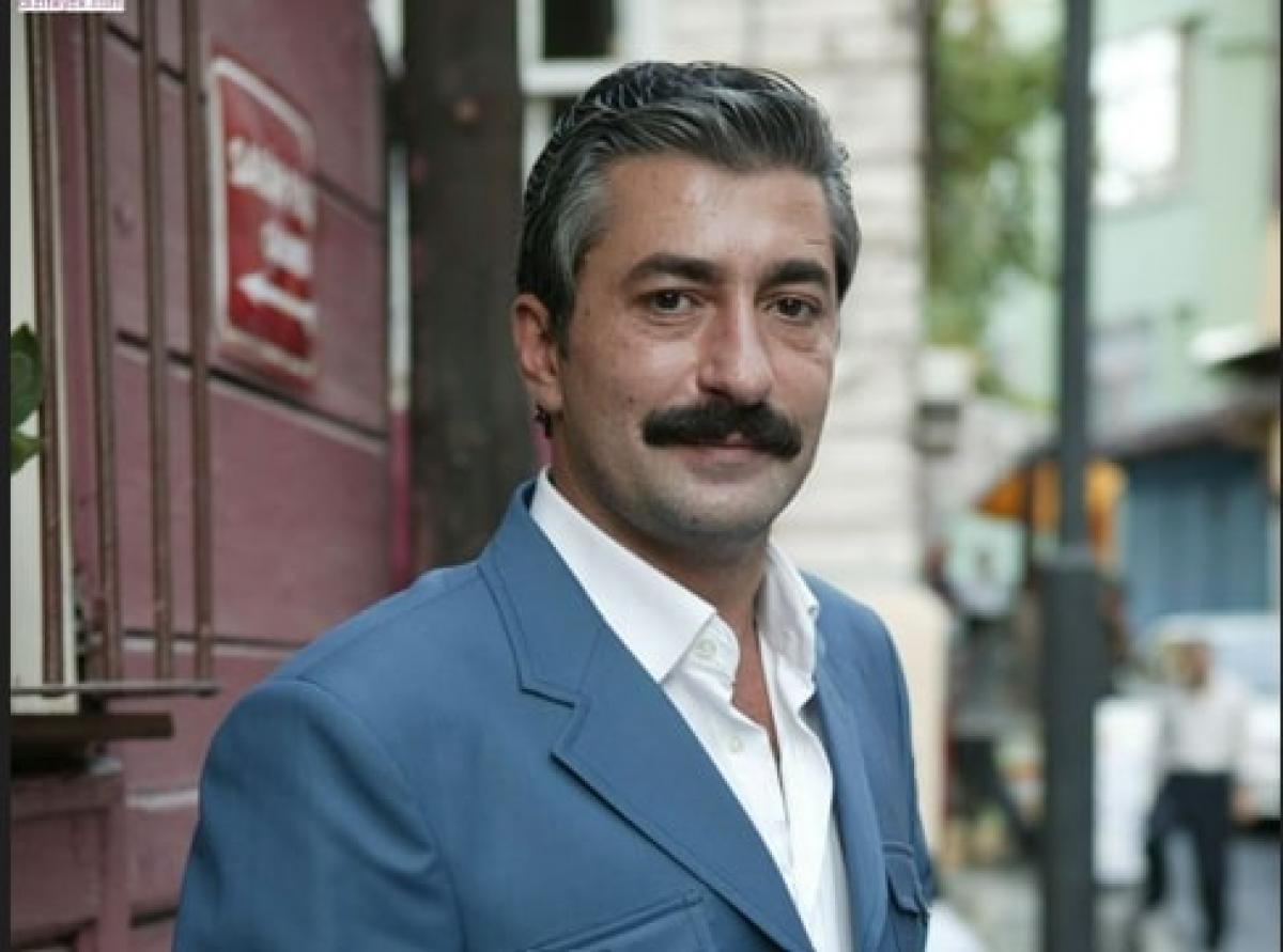 actor poartă o cămașă albă și sacou albastru