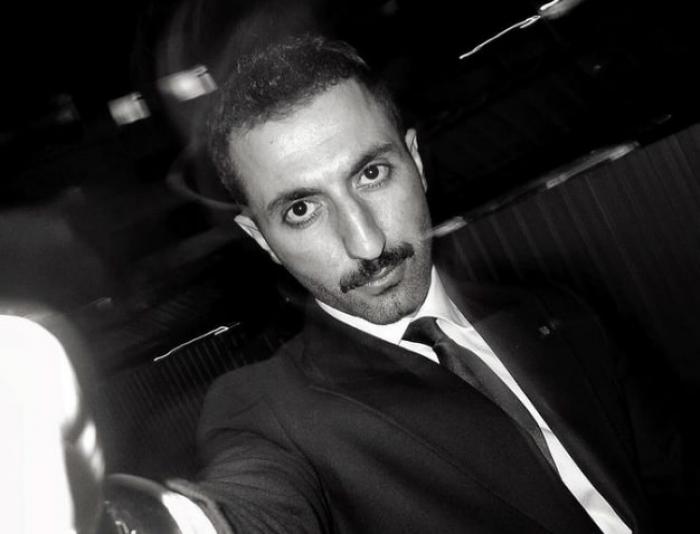 actor poartă o cămașă albă și sacou negru