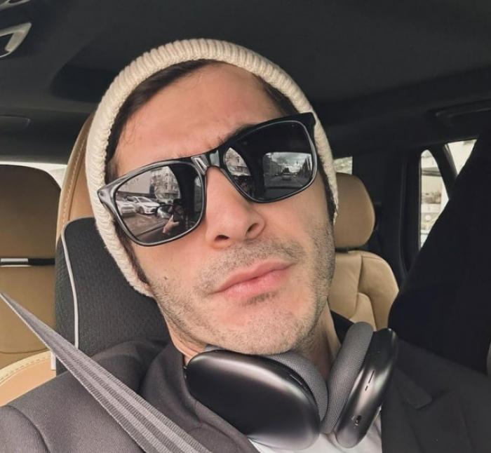 actor poartă căciulă și ochelari de soare