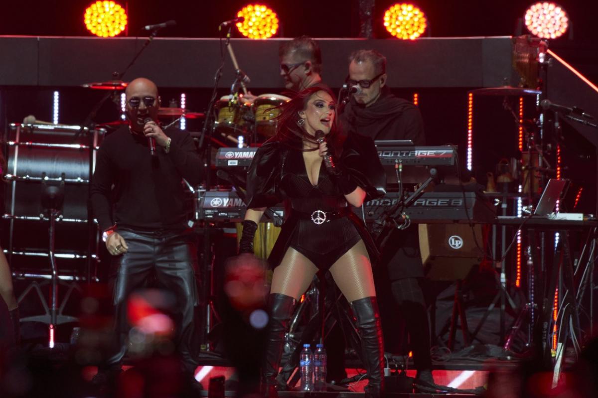 artistă pe scenă într-un costum negru