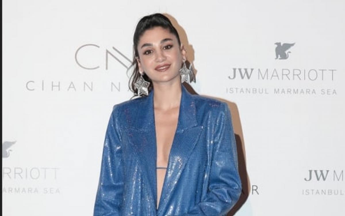 actrița poartă un costum albastru și are părul prins în coadă