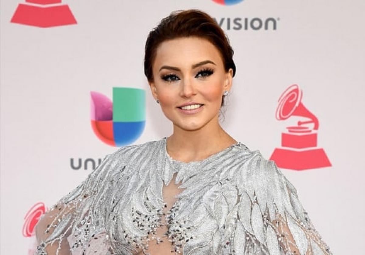 actrița zâmbește și poartă o rochie cu mâneci lungi