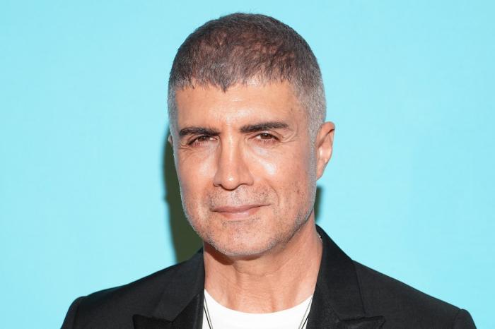 actor poartă tricou alb și sacou negru