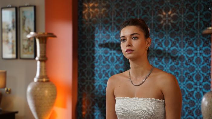 actrița poartă o rochie albă fără mâneci și cu părul prins