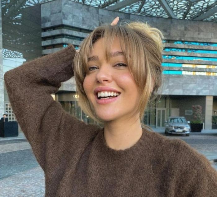 actrița poartă părul în coc și zâmbește