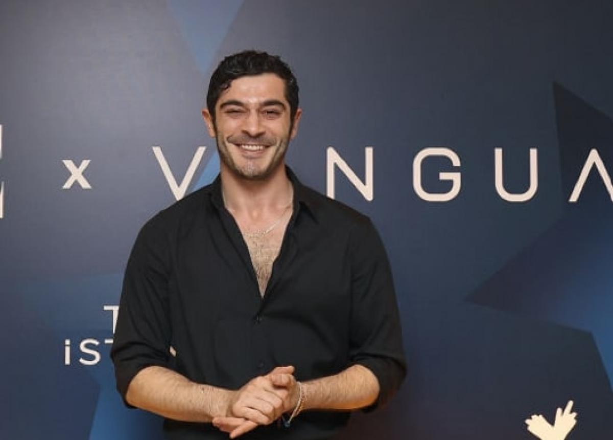 actor poartă o cămașă neagră cu mâneci lungi