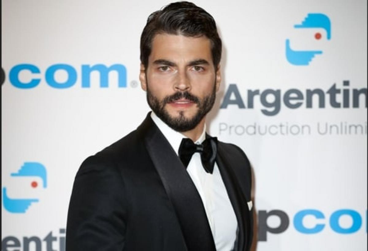 actor poartă o cămașă albă și costum negru