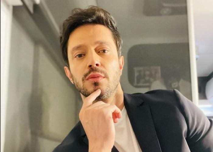 actor poartă un sacou închis la culoare