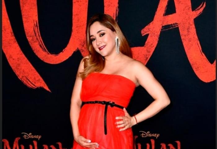 actrița poartă o rochie roșie și are burtică de gravidă