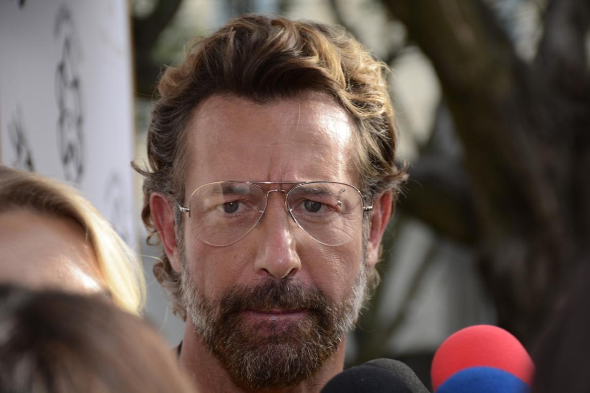 actor în fața microfoanelor poartă ochelari de soare