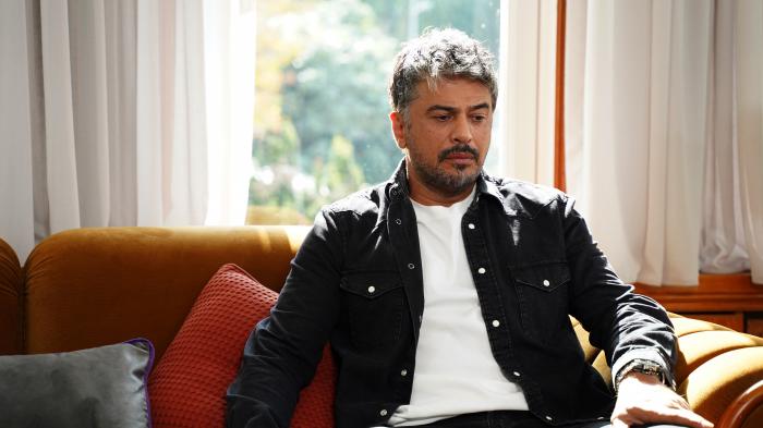 actor poartă tricou alb și cămașă închisă la culoare