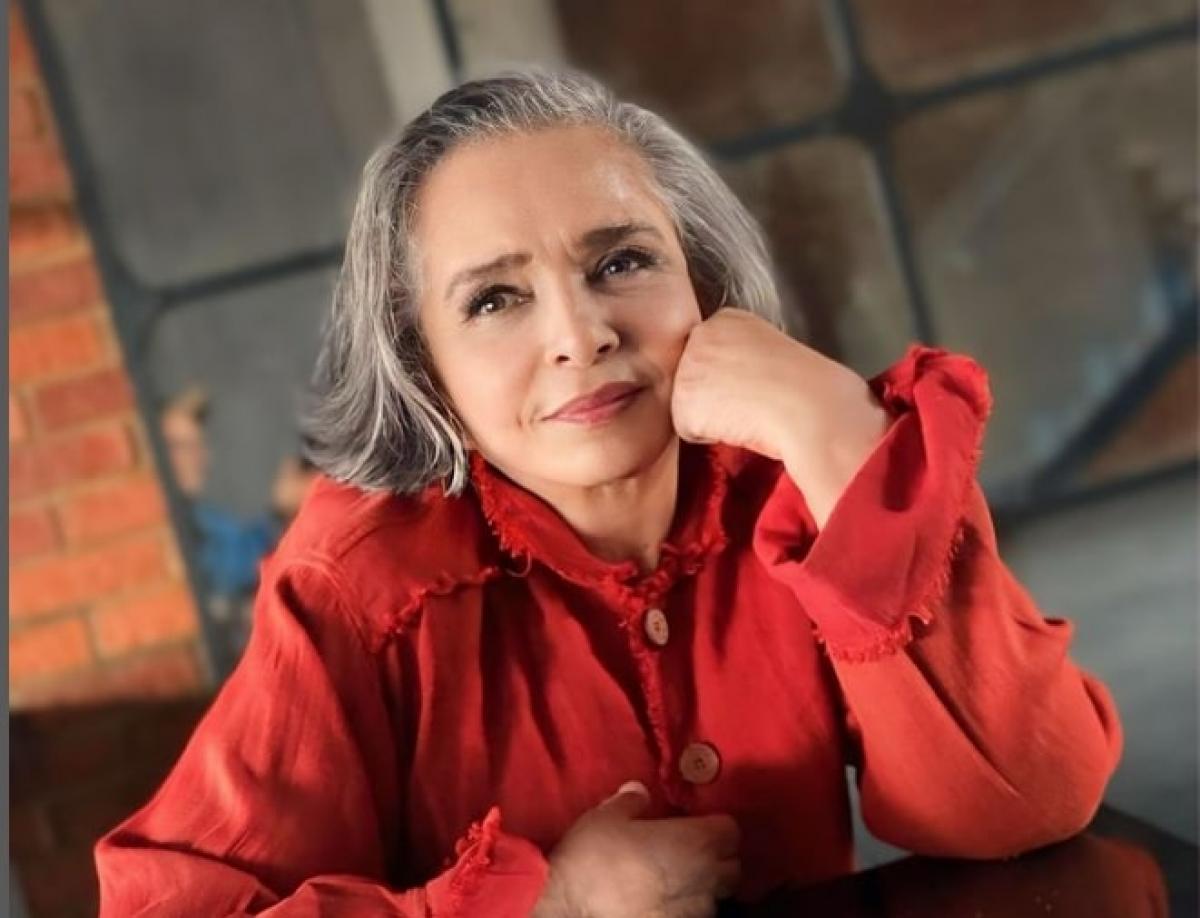 actrița poartă o bluză roșie cu mâneci lungi