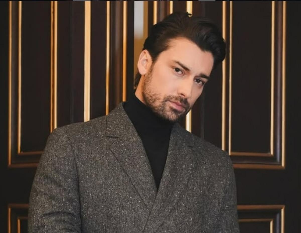 Alp Navruz poartă un costum închis la culoare