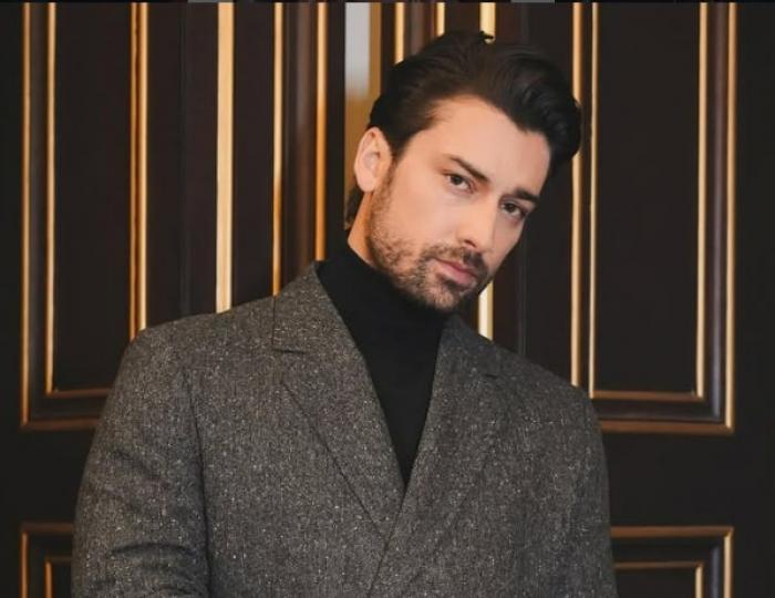 Alp Navruz poartă un costum închis la culoare