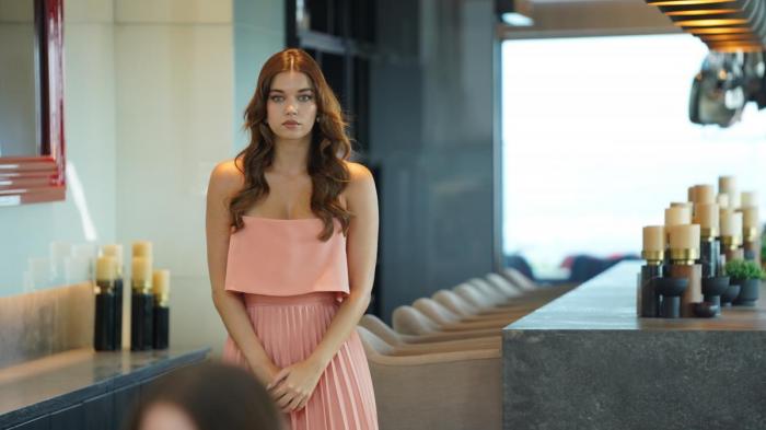 Afra Saracoglu poartă o rochie fără mâneci și părul lung