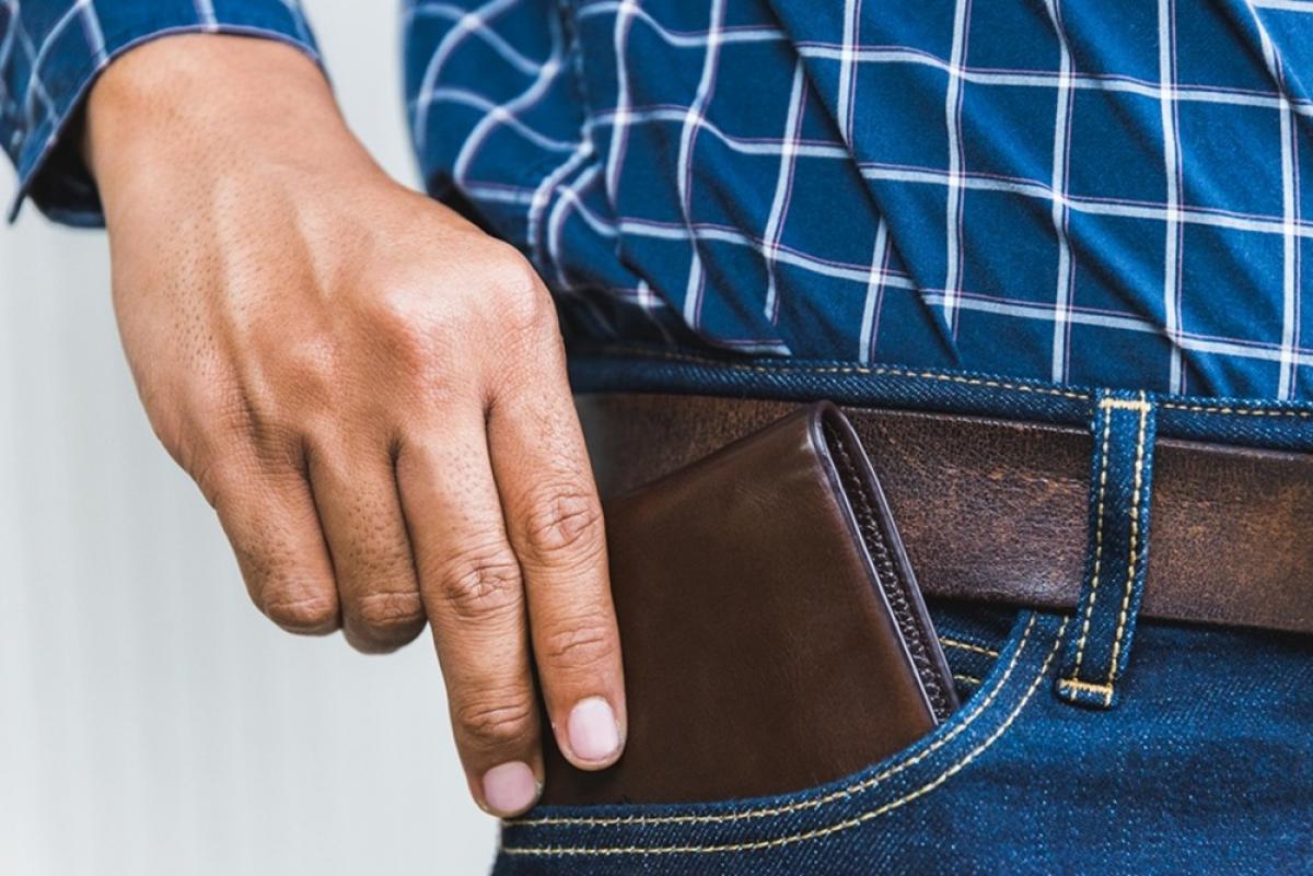 bărbat ce își bagă un portofel în buzunar