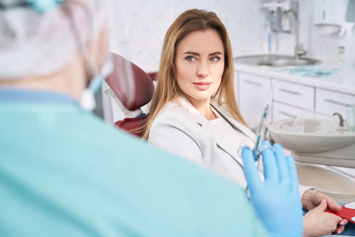 femeie care stă pe scaun la dentist