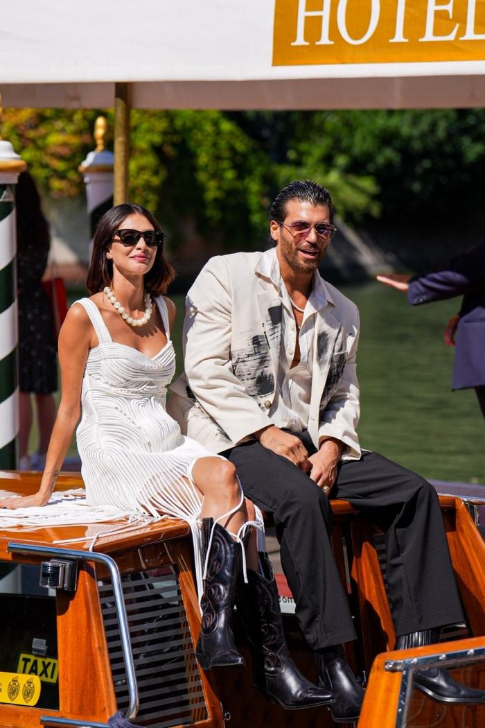 Sara Bluma și Can Yaman stau pe barcă unul lângă celălalt și poartă ochelari de soare