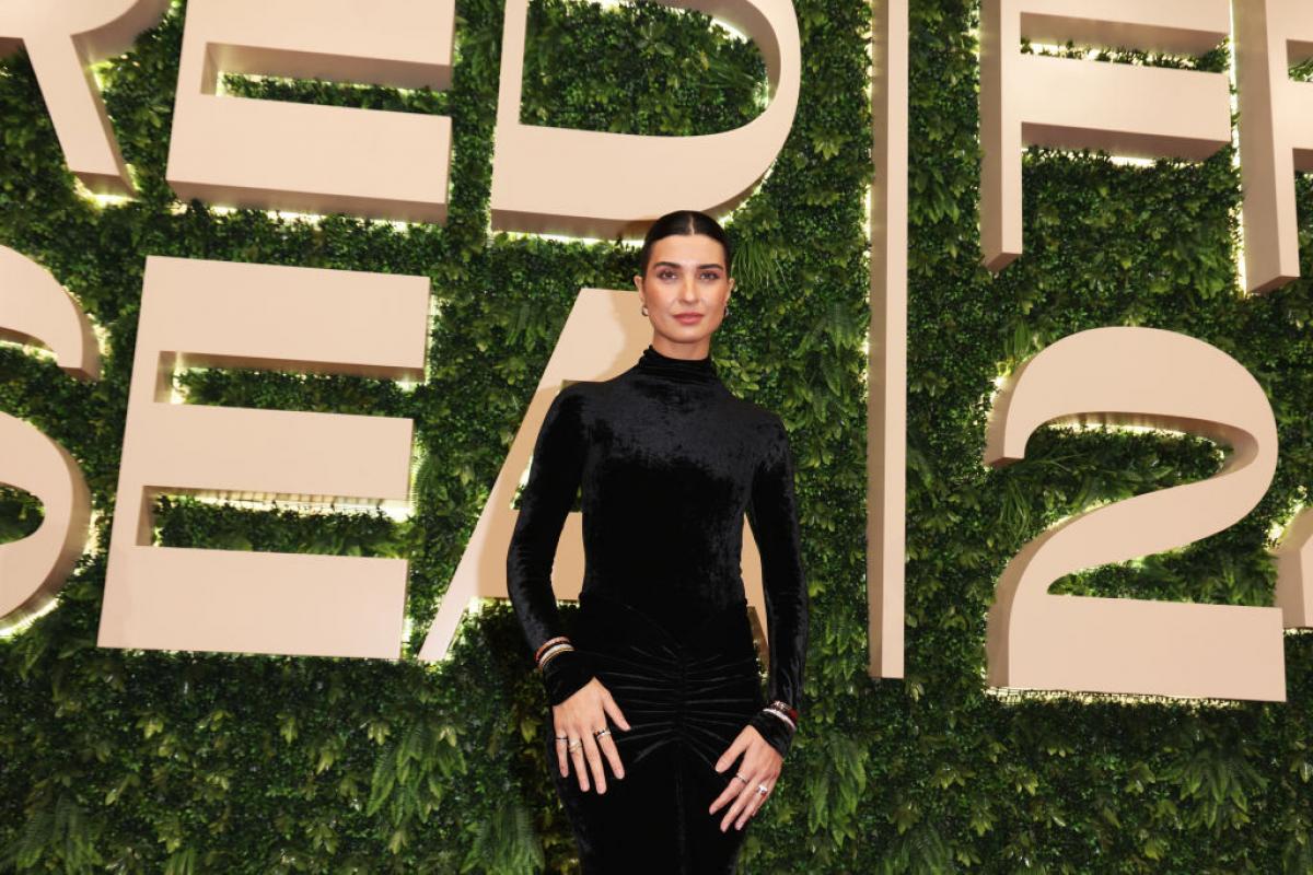 Tuba Büyüküstün poartă o rochie cu mâneci lungi pe un fundal deschis la culoare