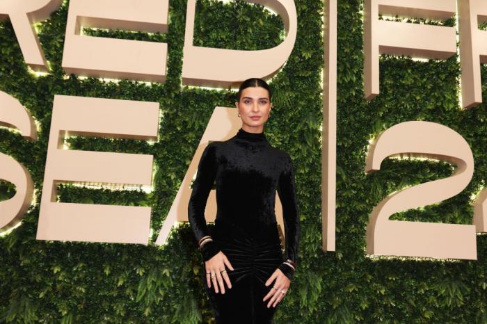 Tuba Büyüküstün poartă o rochie cu mâneci lungi pe un fundal deschis la culoare