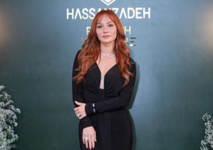 Başak Gümülcinelioğlu poartă o rochie neagră cu mâneci lungi și are părul roșcat