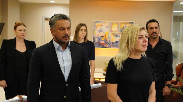 Emre Altug poartă un palton negru