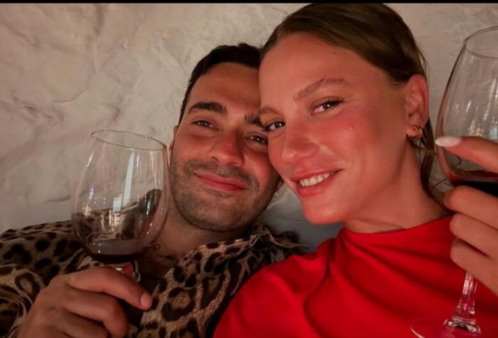 Serenay Sarikaya și Mert Demir stau unul lângă celălalt și zâmbesc