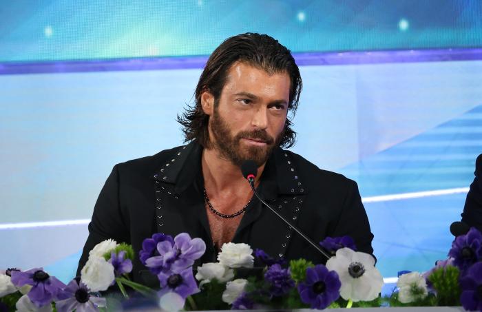 Can Yaman poartă părul desprins și un sacou negru